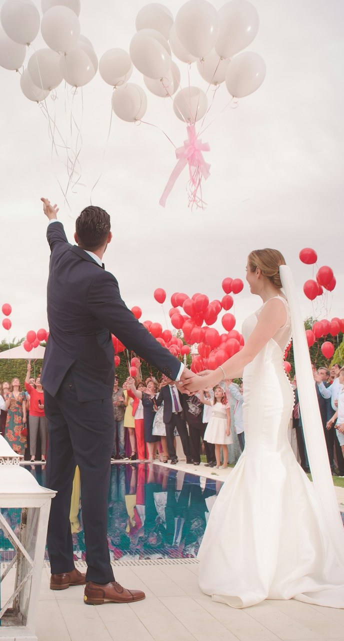 photo of a man and woman newly wedding holding a balloons